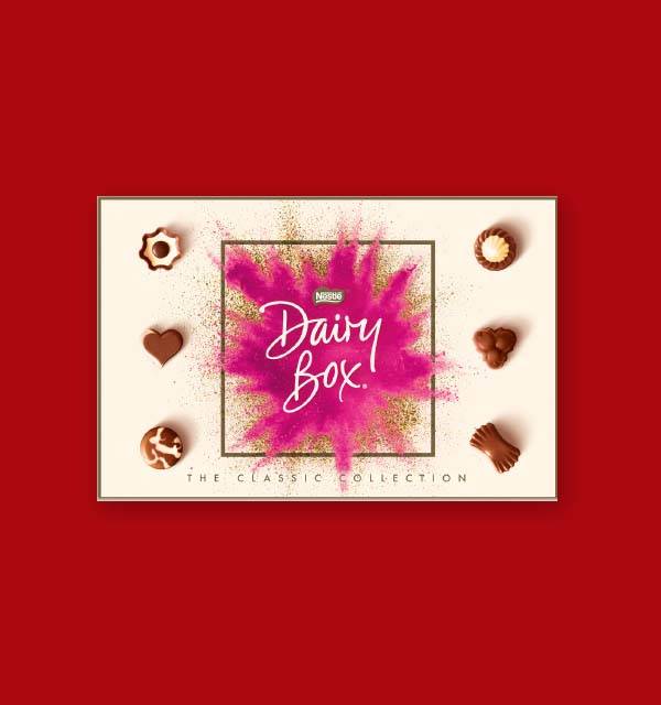 A box of assorted chocolates with a pink and gold burst design, featuring the text 'Dairy Box! The Classic Collection'.
