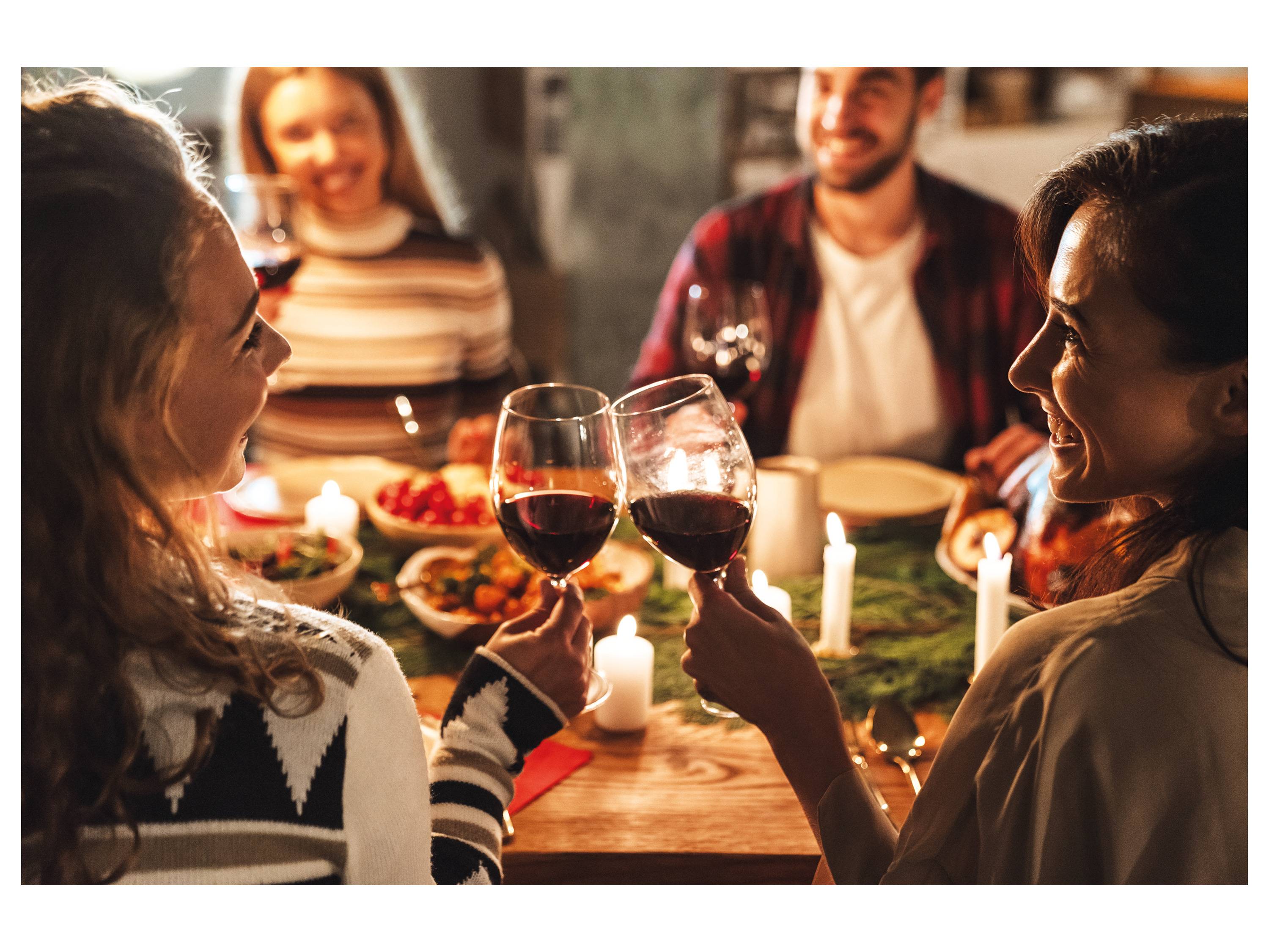 Friends toasting wine at a festive dinner.